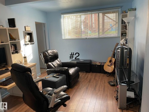 Interior room featuring light blue walls and wood-finish flooring - 10017 113 Street, Edmonton, AB 