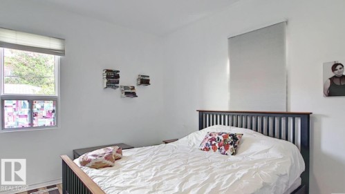 White painted walls, two windows with blinds, and wood-finish flooring - 10017 113 Street, Edmonton, AB 