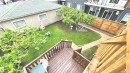 Wood-finish deck with railings overlooking a green lawn - 10017 113 Street, Edmonton, AB 
