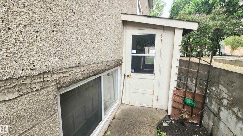 Exterior entry with a partial glass door and a covered stoop - 10017 113 Street, Edmonton, AB 