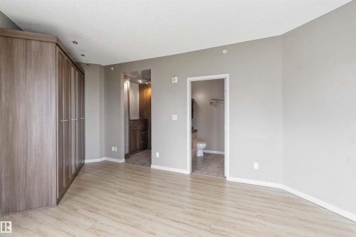 Spacious room featuring wood-finish flooring and neutral wall tones - 901 10504 99 Avenue, Edmonton, AB 