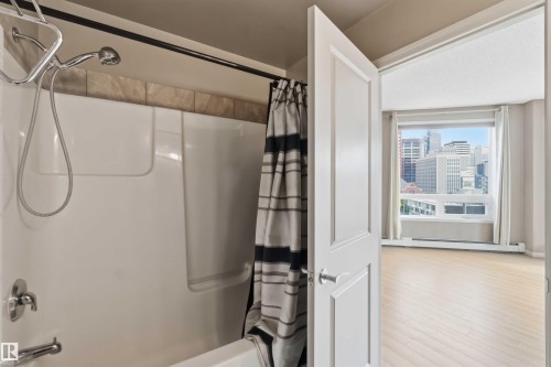 Bathroom featuring a white tub and shower combination with a tile surround - 901 10504 99 Avenue, Edmonton, AB 