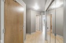 Entryway featuring a wood-finish door, light wood-finish flooring, and a mirrored closet with sliding doors - 901 10504 99 Avenue, Edmonton, AB 