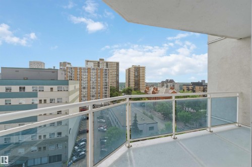 Private balcony featuring a glass and metal railing, concrete flooring, and an urban building backdrop - 901 10504 99 Avenue, Edmonton, AB 