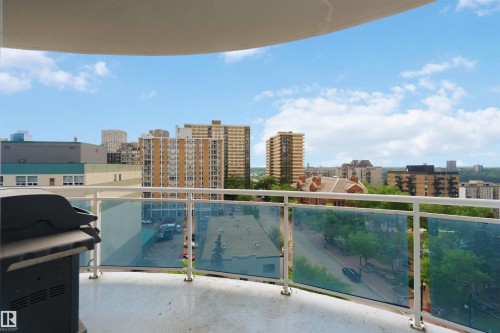 Balcony featuring a curved concrete floor and a metal railing with blue-tinted glass panels - 901 10504 99 Avenue, Edmonton, AB 