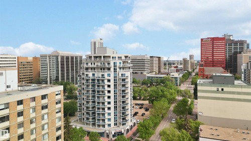 High-rise residential building with multiple balconies, glass railings, and a prominent position within an urban setting - 901 10504 99 Avenue, Edmonton, AB 