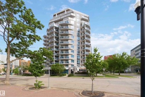 Contemporary high-rise building with a curved architectural facade, glass-paneled balconies, and multiple levels of private outdoor space - 901 10504 99 Avenue, Edmonton, AB 