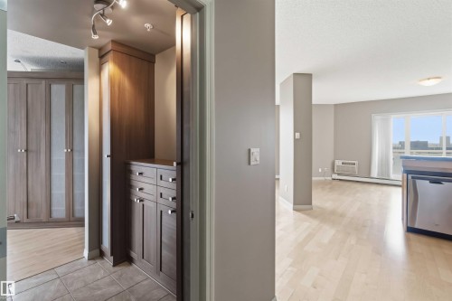 Built-in wood-finish cabinetry and drawers, tile flooring, track lighting, and a dishwasher with a stainless steel finish - 901 10504 99 Avenue, Edmonton, AB 