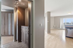 Built-in wood-finish cabinetry and drawers, tile flooring, track lighting, and a dishwasher with a stainless steel finish - 