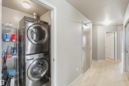 Integrated laundry closet featuring stacked stainless steel appliances and wire shelving - 901 10504 99 Avenue, Edmonton, AB 