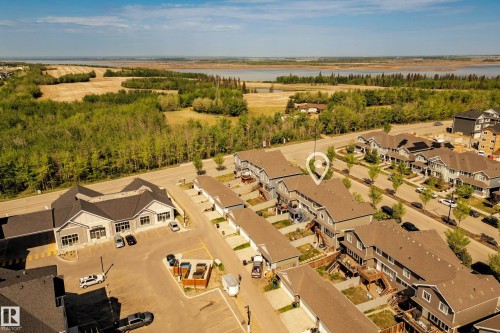 Aerial perspective of a multi-unit residential development with light gray siding and brown shingle roofing - 4013 Blackbird Link, Edmonton, AB 