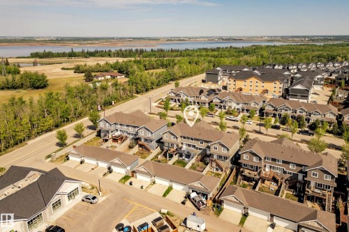 Aerial perspective showcasing residential properties with a water body and expansive green spaces in the background - 4013 Blackbird Link, Edmonton, AB 