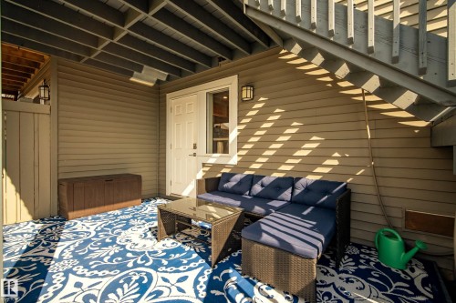 Covered outdoor patio area featuring horizontal siding, overhead decking, and a privacy fence - 4013 Blackbird Link, Edmonton, AB 