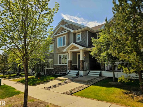 Contemporary multi-level residence featuring mixed material siding, a stone facade on the lower level, and a covered front porch with stone-clad columns - 4013 Blackbird Link, Edmonton, AB 
