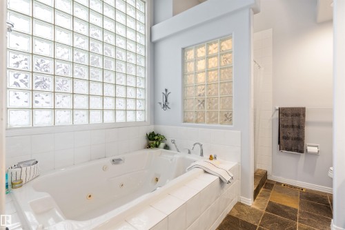 Soaking tub with white tile surround and integrated glass block windows - 10 Everest Crescent, St. Albert, AB 