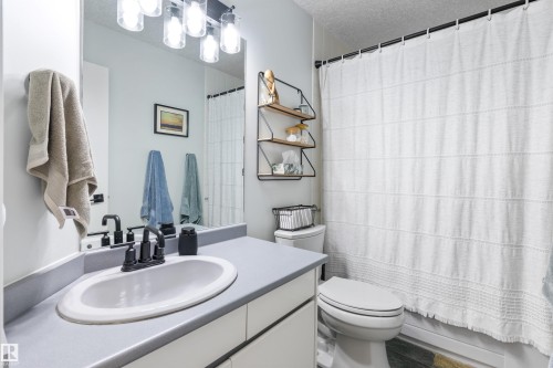 Bathroom vanity featuring an integrated sink, matte black faucet, and a light gray countertop - 10 Everest Crescent, St. Albert, AB 