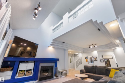 Living area featuring a vaulted ceiling and a fireplace with a tile surround - 10 Everest Crescent, St. Albert, AB 