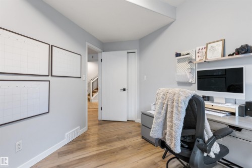 Dedicated office space with wood-finish flooring, light grey wall paint, and white trim - 10 Everest Crescent, St. Albert, AB 