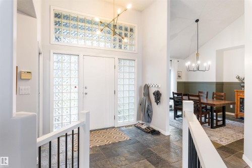 Entryway featuring stone-finish flooring, a white door with glass block sidelights, and a transom window with glass blocks - 10 Everest Crescent, St. Albert, AB 