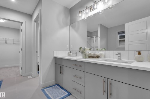Double vanity featuring integrated sinks, light gray cabinetry, and brushed nickel hardware - 1616 157 Street, Edmonton, AB 