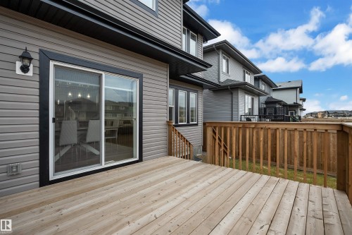 Spacious outdoor deck with natural wood railing, offering direct access to the interior via a sliding glass door - 1616 157 Street, Edmonton, AB 
