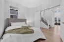 Bedroom featuring light wood-finish flooring, a contemporary window with shades, and a tufted headboard - 1616 157 Street, Edmonton, AB 