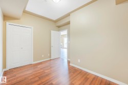 Spacious room featuring wood-finish flooring, light neutral wall tones, and white baseboards - 