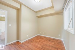 Room featuring wood-finish flooring, neutral wall tones, and white baseboards - 