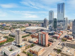 Expansive aerial city panorama showcasing numerous high-rise buildings, a large-scale stadium, and a dense urban landscape with varied architectural styles - 