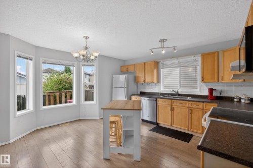Kitchen with wood-finish flooring and light wood cabinetry - 8 Vega Avenue, Spruce Grove, AB - Indoor Photo Showing Kitchen With Double Sink