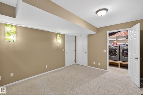 Carpeted room featuring neutral wall paint, two white paneled doors, and ceiling-mounted light fixtures - 8 Vega Avenue, Spruce Grove, AB - Indoor Photo Showing Other Room