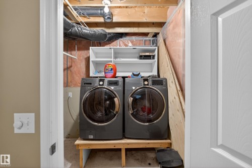 Dedicated laundry area with exposed wood beams and utility piping - 8 Vega Avenue, Spruce Grove, AB - Indoor Photo Showing Laundry Room
