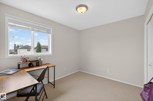 Bedroom featuring a large window with white blinds, neutral wall paint, and beige carpeting - 8 Vega Avenue, Spruce Grove, AB - Indoor