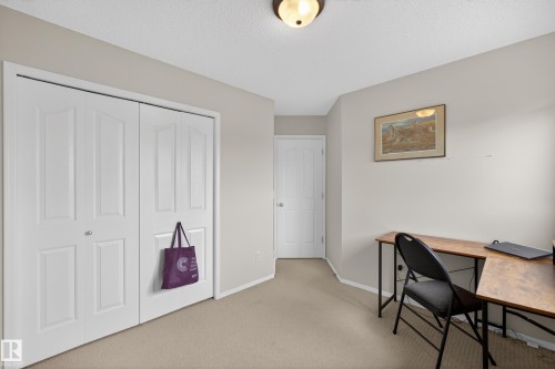 Neutral-toned room featuring a cream-colored ceiling, white bi-fold closet doors, and light beige carpeting - 8 Vega Avenue, Spruce Grove, AB - Indoor