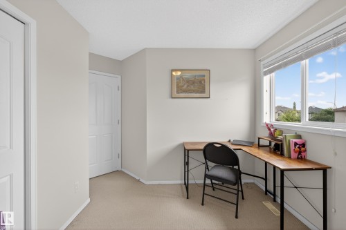 Carpeted room featuring multiple white paneled doors, large window with blinds, and neutral wall paint - 8 Vega Avenue, Spruce Grove, AB - Indoor Photo Showing Office