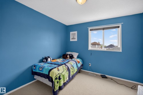 Bedroom featuring a single window with white trim, wall-to-wall carpeting, and a ceiling-mounted light fixture - 8 Vega Avenue, Spruce Grove, AB - Indoor Photo Showing Bedroom