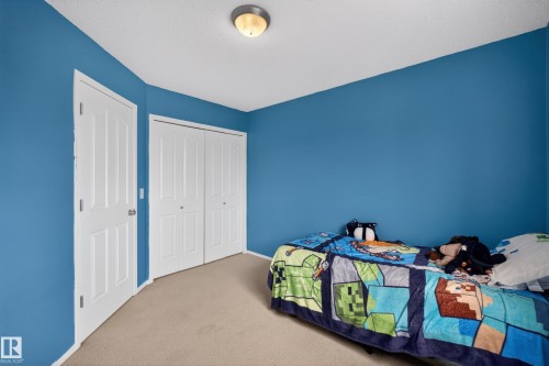 Room with blue walls, light-colored carpeting, a white ceiling, and a flush-mount ceiling light fixture - 8 Vega Avenue, Spruce Grove, AB - Indoor Photo Showing Bedroom