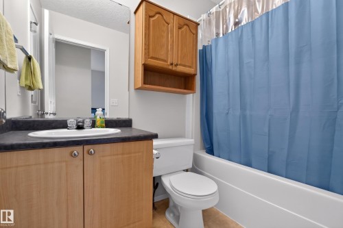 Bathroom featuring a vanity with a laminate countertop, undermount sink, and wood-finish cabinetry - 8 Vega Avenue, Spruce Grove, AB - Indoor Photo Showing Bathroom