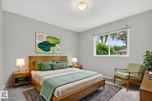 Bright bedroom with a large window, light gray walls, and light-toned carpeting - 9740 65 Avenue Nw, Edmonton, AB 