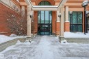 Building entrance featuring an overhead portico, prominent support columns, and large glass entry doors - 1407 9939 109 Street, Edmonton, AB 
