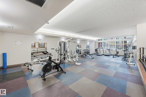 Fitness center featuring a tiled floor, recessed lighting, and multiple exercise machines - 1407 9939 109 Street, Edmonton, AB 