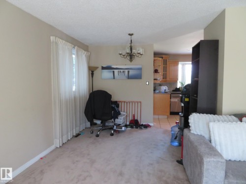 Living area featuring textured carpeting and neutral wall tones - 10720 57 Avenue, Edmonton, AB 