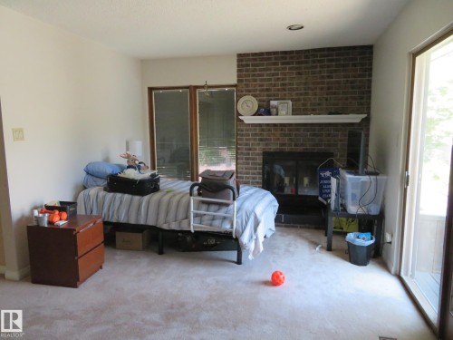 Living area featuring a brick fireplace with a white mantel, sliding glass doors, and recessed lighting - 10720 57 Avenue, Edmonton, AB 