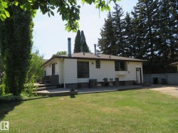 Exterior featuring white siding, a dark shingle roof, and multiple windows - 