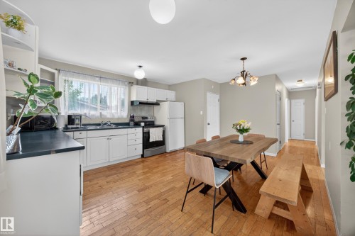Kitchen and dining area featuring wood-finish flooring - 5216 104A Street, Edmonton, AB - Indoor