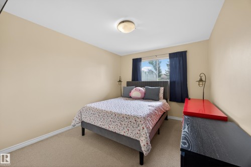 Bedroom featuring carpet flooring, neutral-toned walls, and a window with a distant landscape - 5216 104A Street, Edmonton, AB - Indoor Photo Showing Bedroom