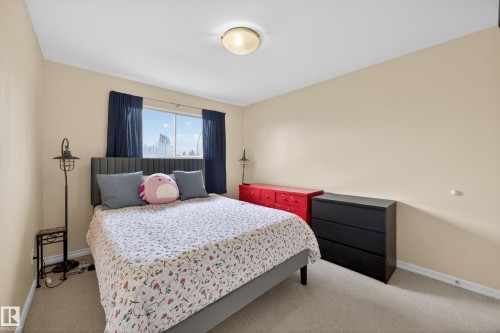 Carpeted room with a central window, featuring a ceiling-mounted light fixture and light-colored walls - 5216 104A Street, Edmonton, AB - Indoor Photo Showing Bedroom