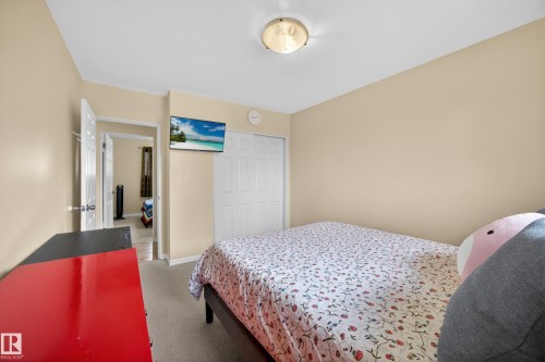 Bedroom featuring neutral wall paint, carpet flooring, a flush-mount ceiling light, and bi-fold closet doors - 5216 104A Street, Edmonton, AB - Indoor Photo Showing Bedroom