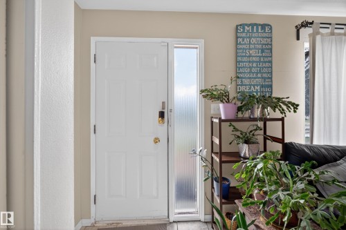 Entry door with sidelight window, featuring a multi-panel design and a brass-tone doorknob - 5216 104A Street, Edmonton, AB - Indoor Photo Showing Other Room