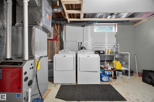 Utility room featuring a furnace, water heater, and laundry appliances - 5216 104A Street, Edmonton, AB - Indoor Photo Showing Laundry Room